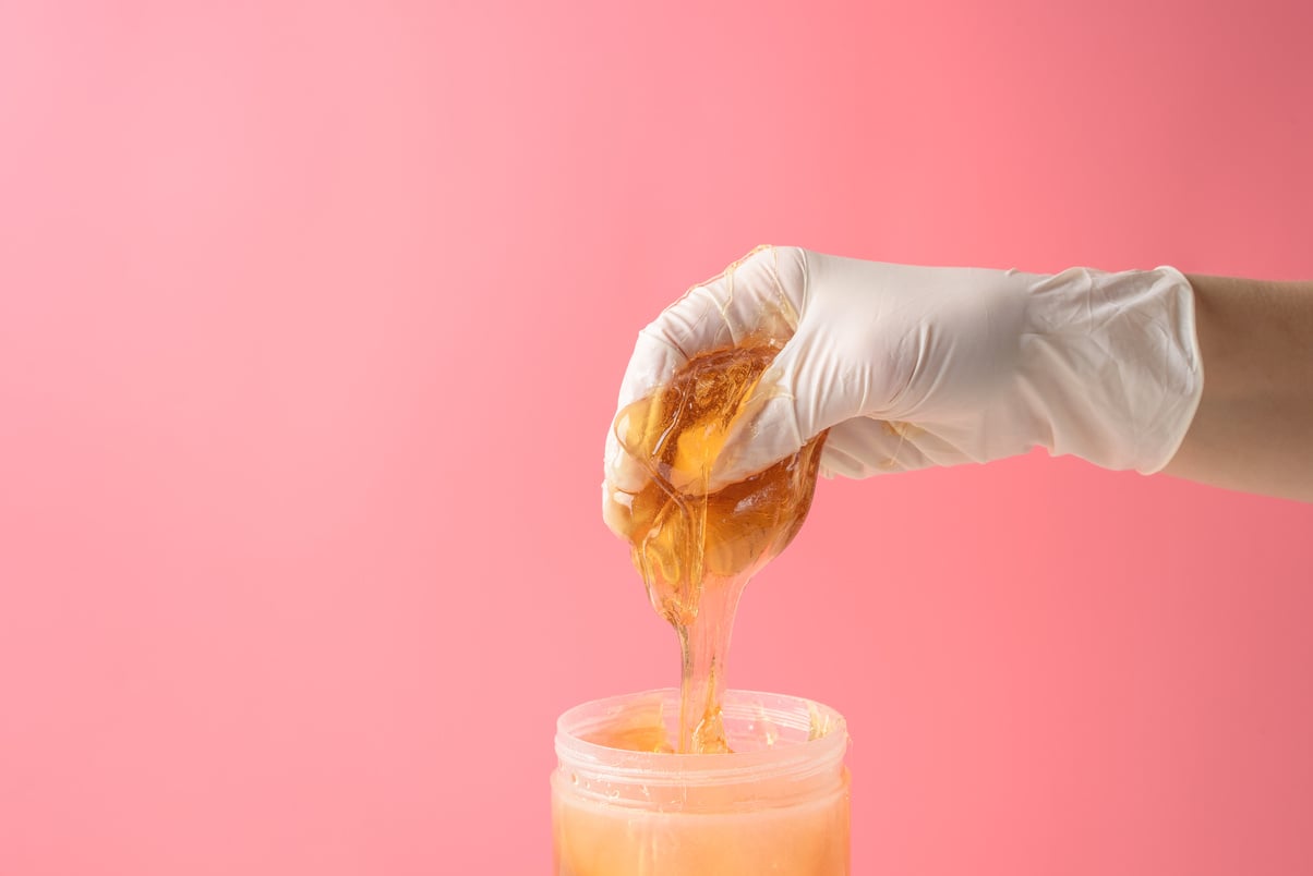 Hand with Sugar Wax Piece from Jar